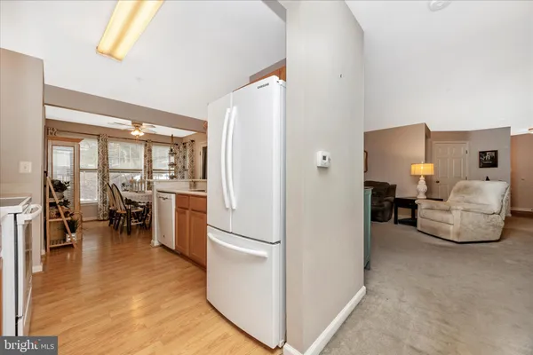 a living room with furniture and a dining table with wooden floor