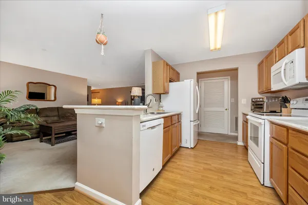 a kitchen with sink a refrigerator and wooden floor