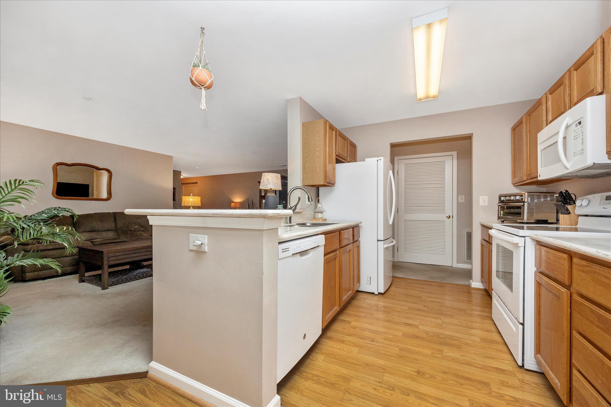 25900 Ridge Manor Drive, Unit 6000B Damascus, MD 20872 - Photo 15 of 39 a kitchen with sink a refrigerator and wooden floor