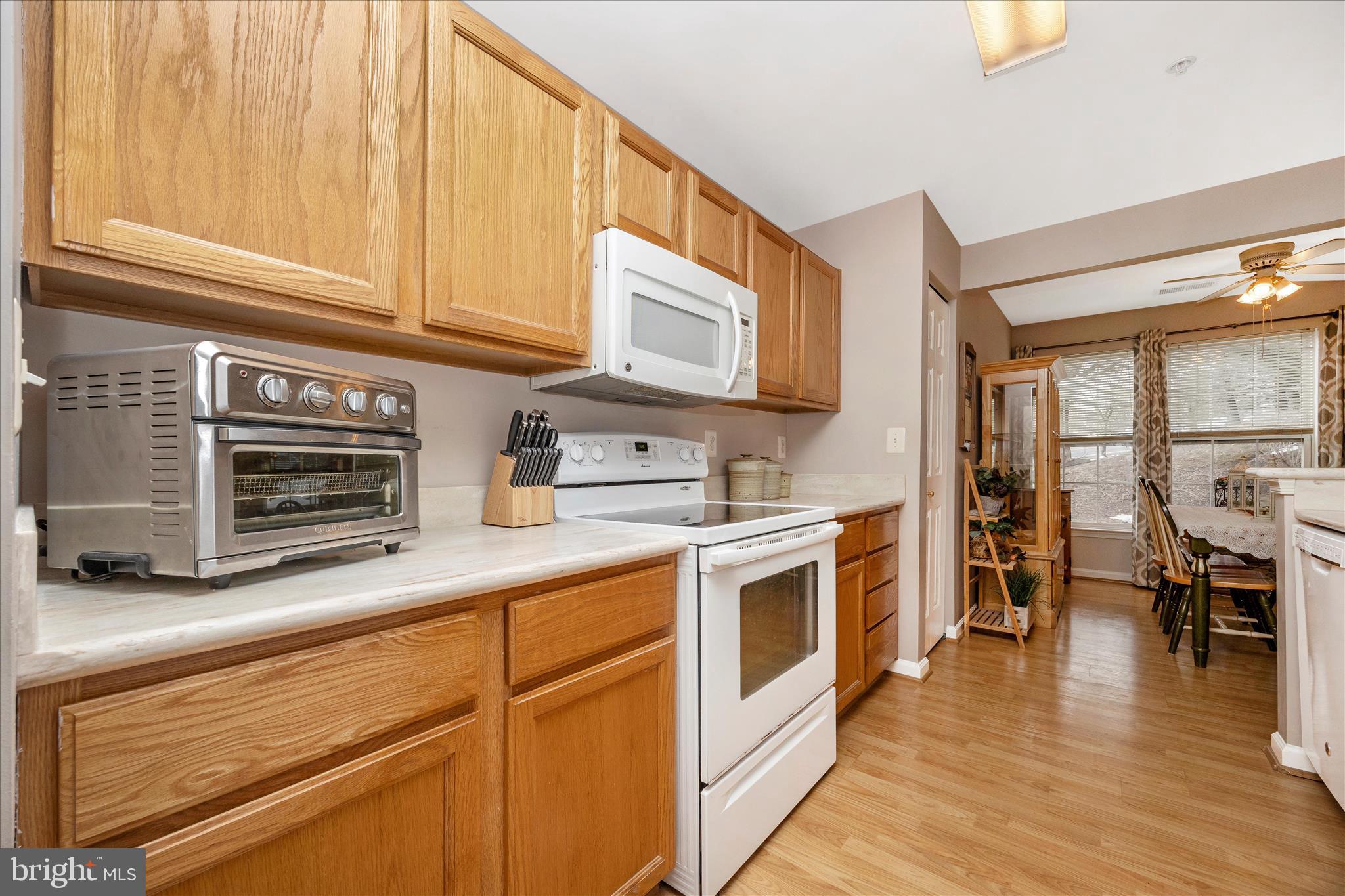 25900 Ridge Manor Drive, Unit 6000B Damascus, MD 20872 - Photo 19 of 39 a kitchen with stainless steel appliances granite countertop a stove and white cabinets
