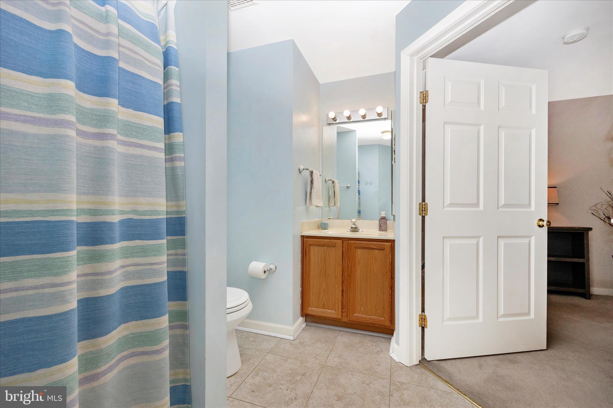 25900 Ridge Manor Drive, Unit 6000B Damascus, MD 20872 - Photo 21 of 39 a bathroom with a granite countertop sink a toilet and shower