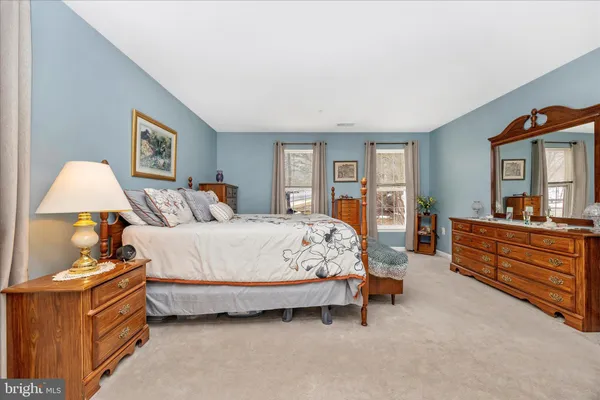 a spacious bedroom with a bed and a dresser in it