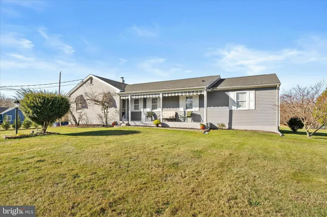 a backyard of a house with table and chairs and potted plants