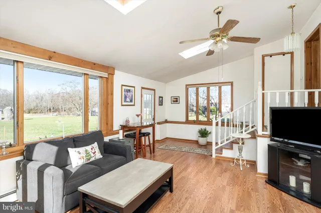 a living room with furniture a large window and a flat screen tv