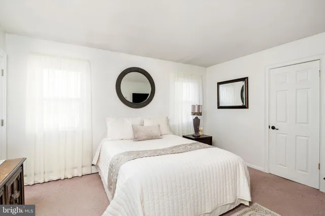 a bedroom with a bed and a lamp on the dresser