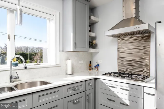 a kitchen with stainless steel appliances granite countertop a sink and a stove