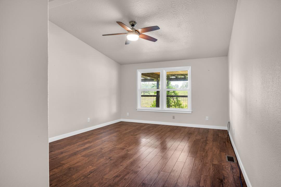 10721 Shenandoah Road Plymouth, CA 95669 - Photo 26 of 48 a view of an empty room with wooden floor and a window