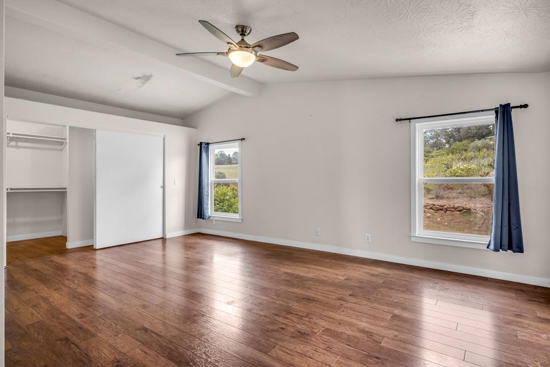 10721 Shenandoah Road Plymouth, CA 95669 - Photo 28 of 48 an empty room with wooden floor chandelier fan and windows