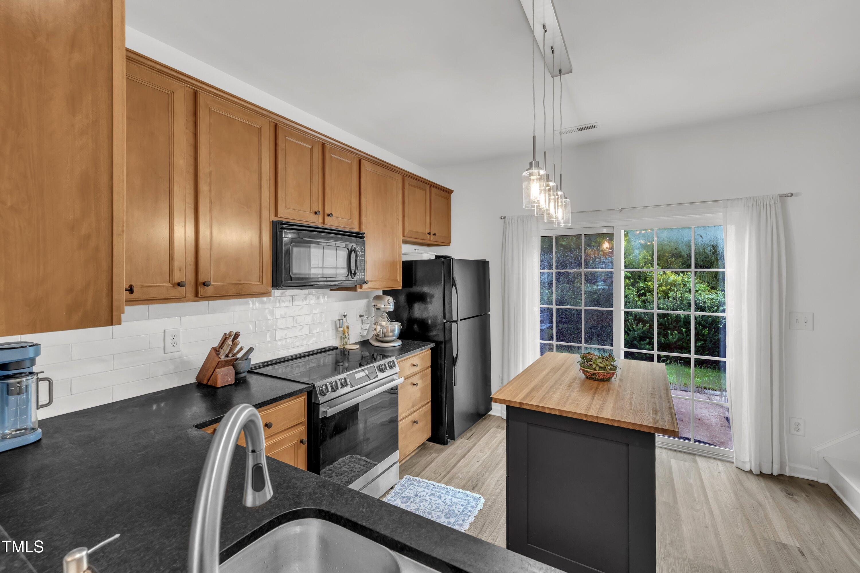 3583 Sugar Tree Place Durham, NC 27713 - Photo 13 of 50 a kitchen with sink a refrigerator and chairs