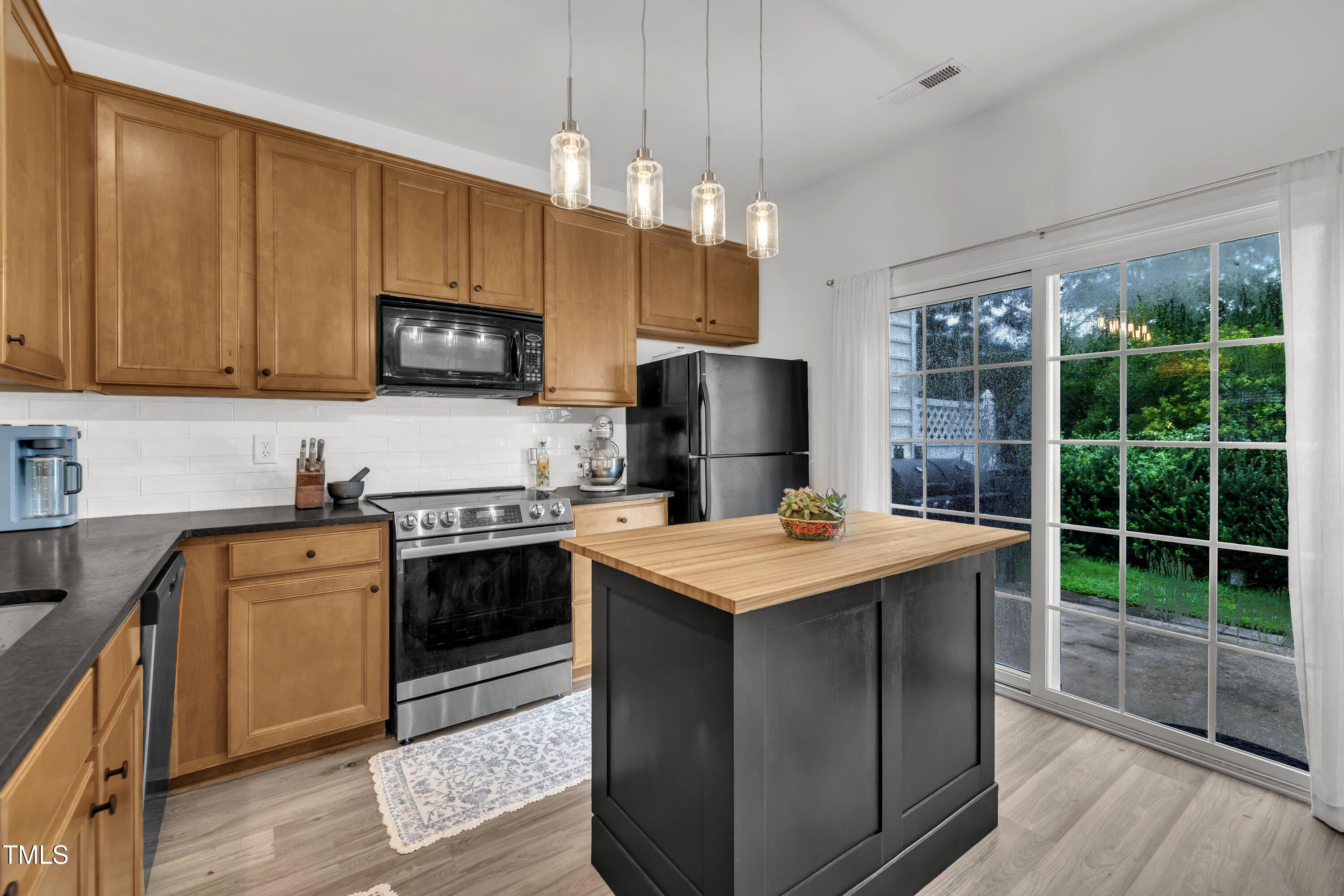3583 Sugar Tree Place Durham, NC 27713 - Photo 14 of 50 a kitchen with kitchen island a sink stove and refrigerator