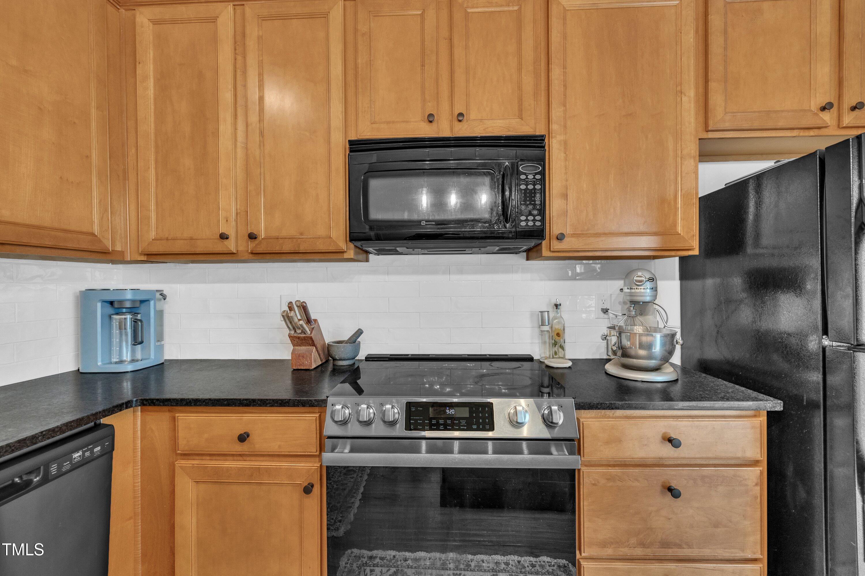 3583 Sugar Tree Place Durham, NC 27713 - Photo 18 of 50 a kitchen with stainless steel appliances granite countertop a stove a microwave and cabinets