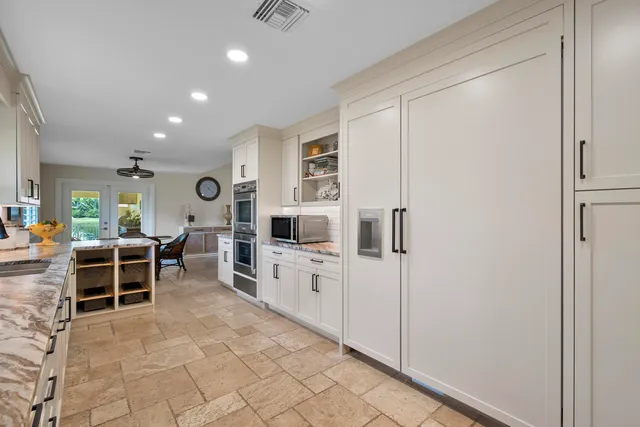 a large white kitchen with cabinets