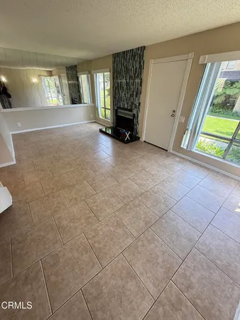 a view of an empty room with window and stairs