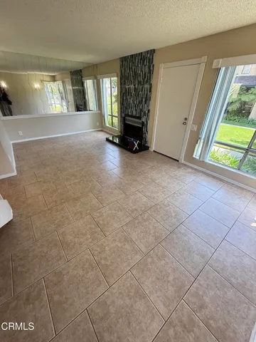 a view of an empty room with window and stairs