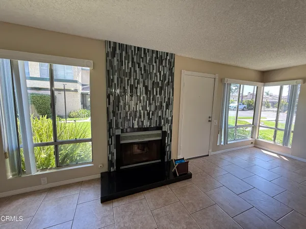 a view of an empty room with a fireplace and a window