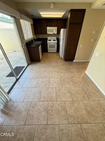 a view of a refrigerator in kitchen and a sink