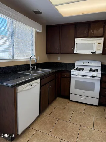 a kitchen with a sink stove top oven and cabinets