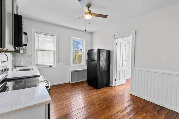 a kitchen with stainless steel appliances granite countertop a refrigerator a sink and dishwasher with wooden floor