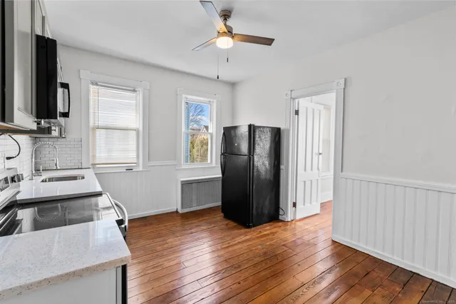 a kitchen with stainless steel appliances granite countertop a refrigerator a sink and dishwasher with wooden floor