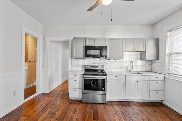 a kitchen with stainless steel appliances a stove a sink and a microwave