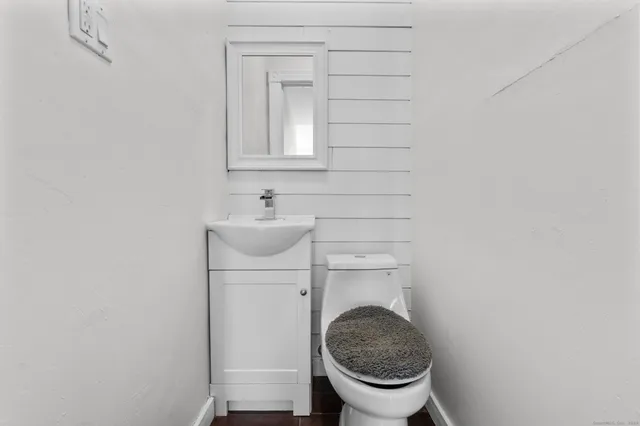 a bathroom with a toilet a sink and a mirror