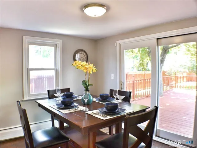 a view of a dining room with furniture a chandelier and wooden floor