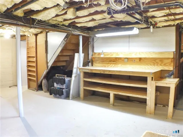 a view of walk in closet with an empty room and wooden floor