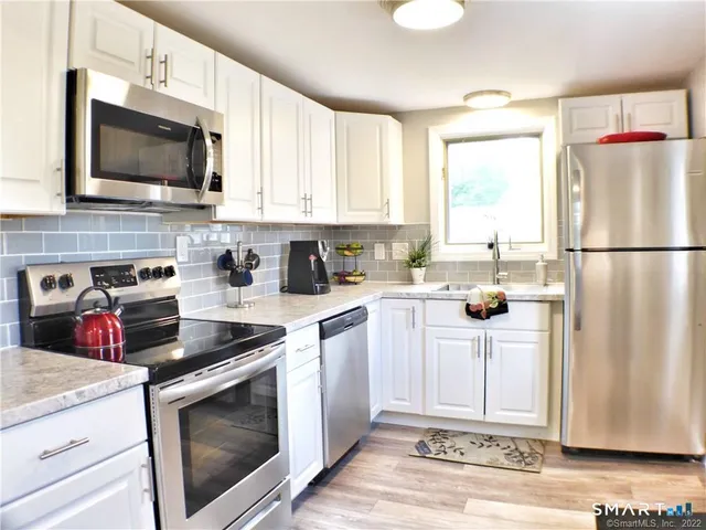 a kitchen with stainless steel appliances granite countertop a stove a sink and a microwave