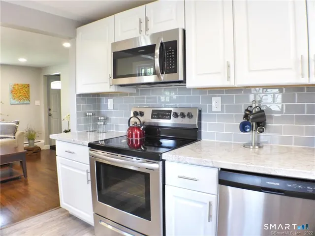 a kitchen with stainless steel appliances granite countertop a sink a stove a microwave and cabinets