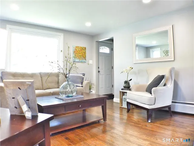 a living room with furniture and wooden floor