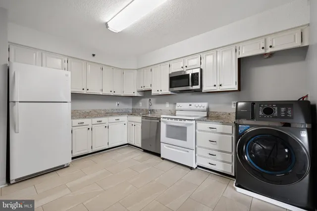 a kitchen with stainless steel appliances granite countertop a stove a microwave and a sink