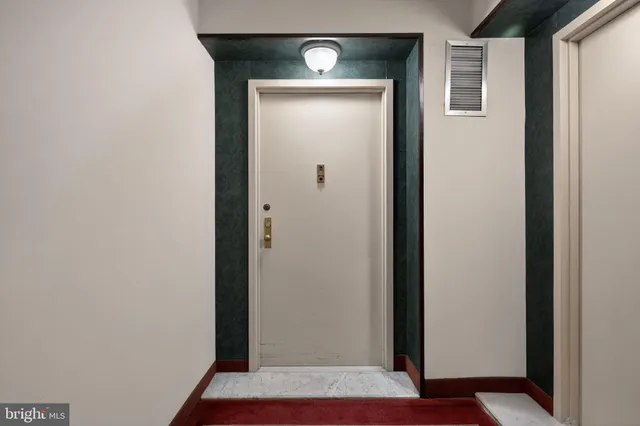 a view of a hallway with wooden floor and a door