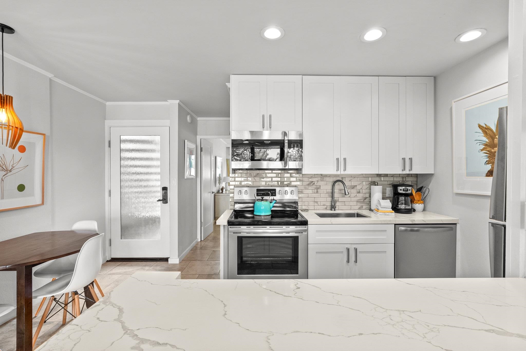 4057 Lower Honoapiilani Road, Unit 114 Lahaina, HI 96761 - Photo 11 of 23 a kitchen with stainless steel appliances a stove a sink and a refrigerator