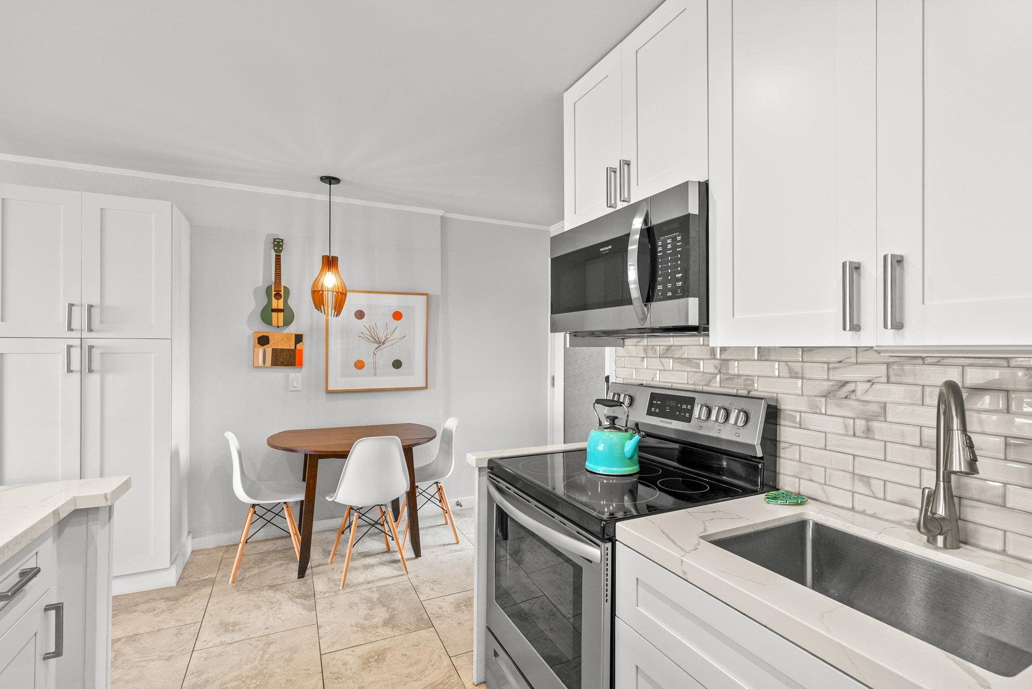4057 Lower Honoapiilani Road, Unit 114 Lahaina, HI 96761 - Photo 12 of 23 a kitchen that has a sink and a stove top oven