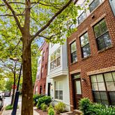 a view of a brick house with a large tree