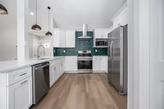 a kitchen with stainless steel appliances granite countertop a stove and cabinets