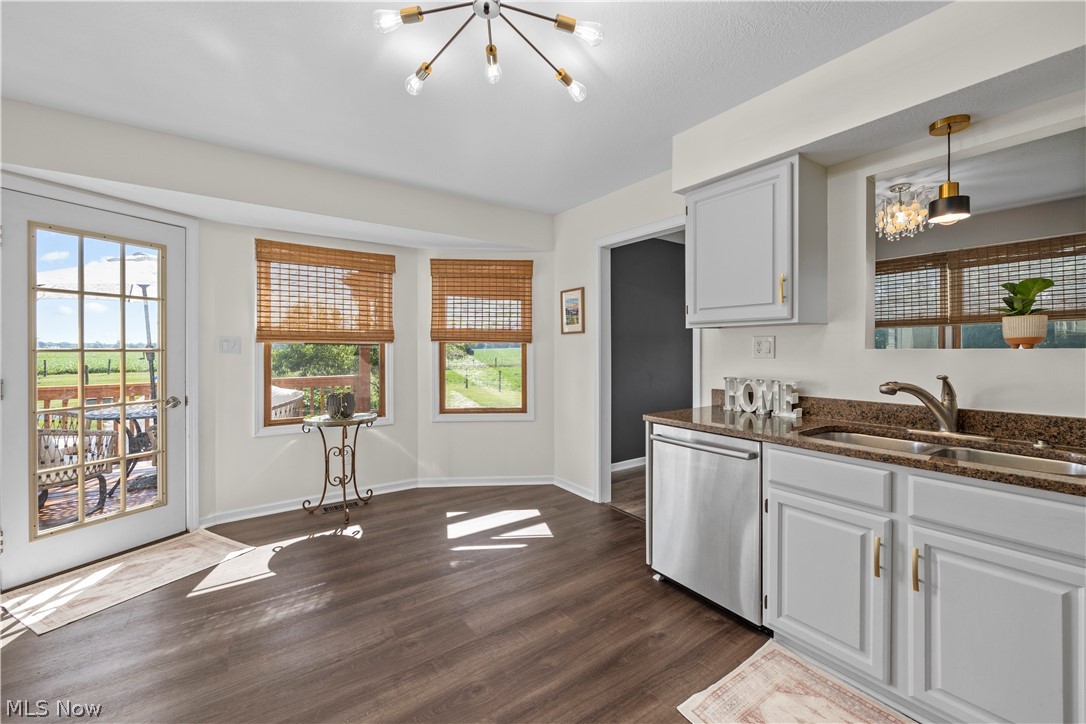 14120 Mason Road Vermilion, OH 44089 - Photo 12 of 50 Kitchen with dark hardwood / wood-style flooring, pendant lighting, sink, dishwasher, and an inviting chandelier