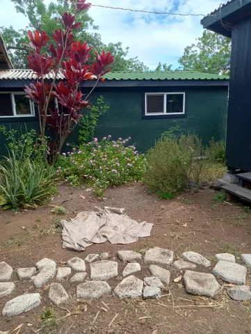 a front view of a house with a yard and potted plants