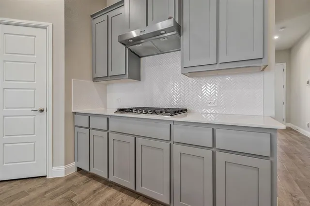 a kitchen with stainless steel appliances granite countertop a sink and a white cabinets