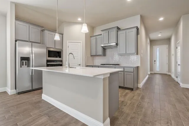 a kitchen with stainless steel appliances a refrigerator sink and stove