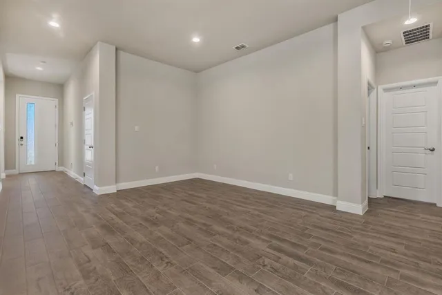 a view of an empty room with wooden floor