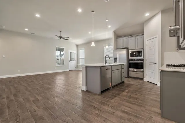 a large kitchen with a large counter top appliances and cabinets