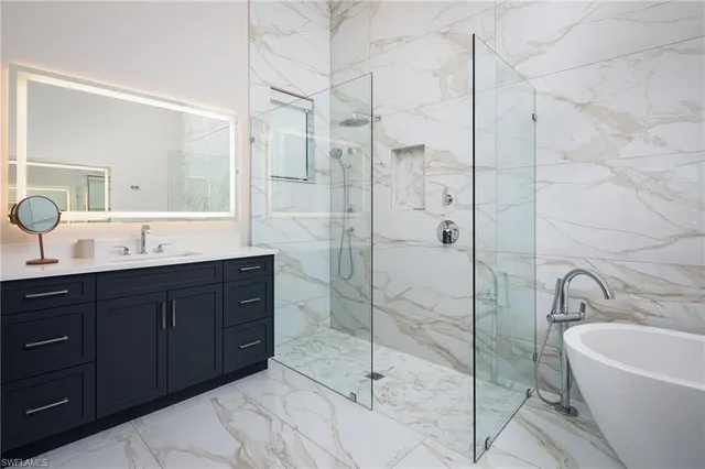 a bathroom with a tub sink shower and mirror