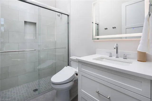 a bathroom with a sink a toilet and shower