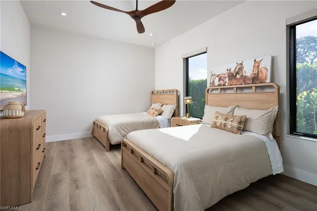 a bedroom with two beds and painting on the wall