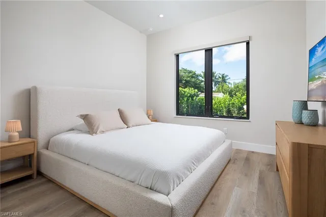 a large bed sitting in a bedroom next to a window