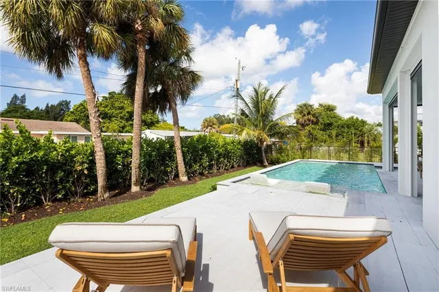 a view of a backyard with plants and palm trees