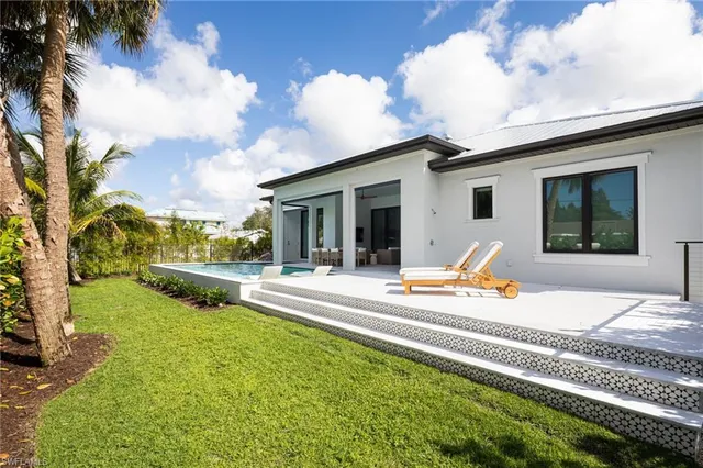 a view of a house with swimming pool and sitting area