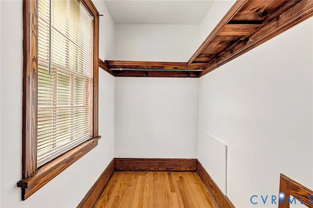 a view of empty room with wooden floor and fan
