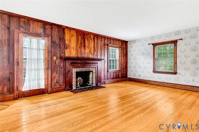 wooden floor fireplace and windows in an empty room